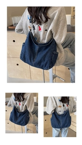Vue détaillée du sac hobo en jean bleu foncé avec coutures contrastées et bandoulière