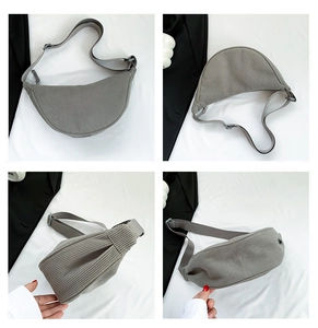 Detail view of grey corduroy crescent bag showing zippers and adjustable nylon strap