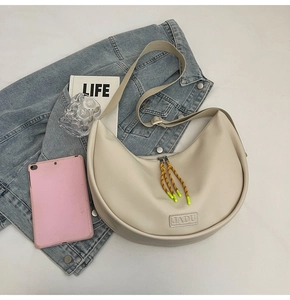 Détail du sac croissant crème avec logo JADU et tirette de fermeture jaune vif