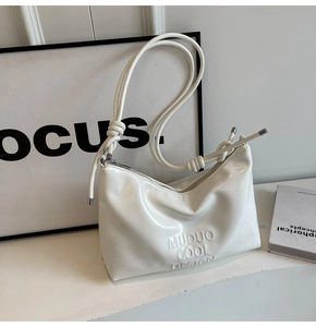 Close-up of white glossy hobo bag with MUDUO COOL DESIGN embossing and knotted cord strap