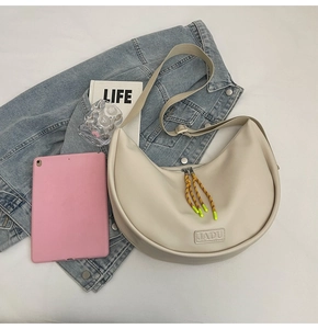 Détail du sac croissant crème avec logo JADU et tirette de fermeture en corde tressée