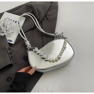 Detailed view of silver metallic pleated shoulder bag with heart charm and pearl chain