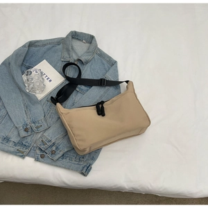 Detail of beige large capacity dumpling bag with zipper closure and black nylon strap