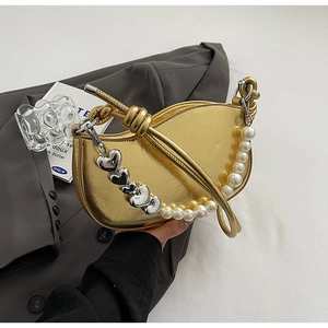 Detail of gold metallic crescent bag with faux pearl and silver heart pendants