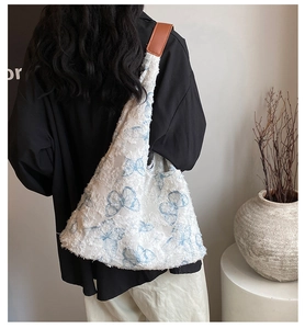 Detail of embroidered butterfly tote bag with plush texture and brown leather straps