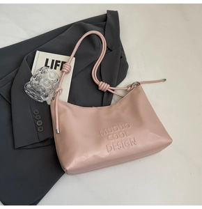 Detail of light pink shoulder bag with embossed Muduo Cool Design text and knotted strap