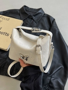 Chic cream bucket bag with silver cracked finish and metallic butterfly accent