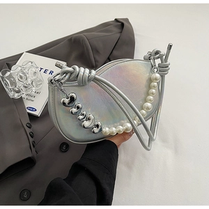 Detail of silver crescent bag with pearl and heart metal charm shoulder strap