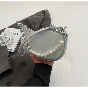 Close-up of silver iridescent hobo bag with pearl chain and heart charms detail