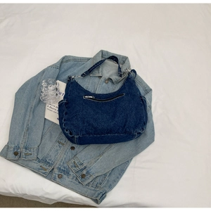 Détails du sac hobo en jean bleu vintage avec boucles argentées et poche zippée pratique