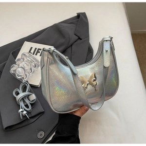 Dettaglio borsa a mezzaluna argento olografico con farfalla metallica e texture effetto pelle