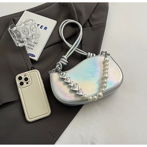 Detail view of laser silver crescent bag with pearl chain and heart charms decoration