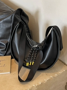 Grand sac hobo noir mat avec fermeture éclair en corde sur une surface en pierre