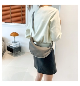 Detail of grey corduroy crescent bag showing fabric texture and adjustable strap