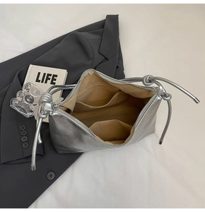 Detailed view of the silver metallic shoulder bag interior with lining and pockets