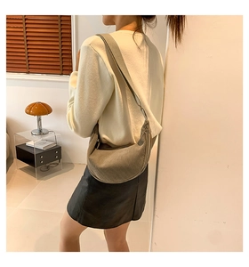 Detail view of coffee-colored corduroy half-moon bag texture with a wide shoulder strap