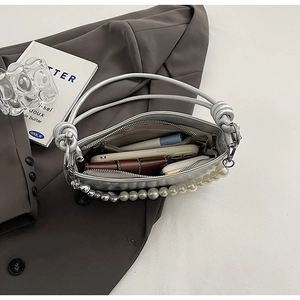 Internal view showing interior pocket and storage capacity of silver pearl shoulder bag