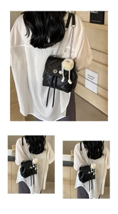 Détail du mini sac à dos noir matelassé avec bandoulière chaîne et charm en peluche doux