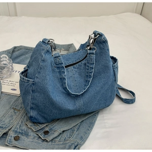 Détails du sac cabas en denim bleu avec poches latérales et fermeture éclair métallique