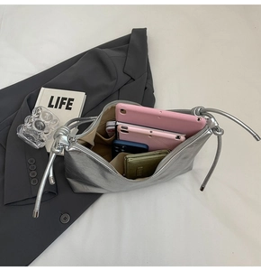 Silver metallic shoulder bag with drawstring knots showing large capacity for tablets