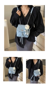 Détail du sac à dos matelassé bleu clair avec chaînes argentées et fermoir pivotant