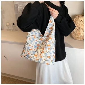 Detailed close-up of a floral canvas tote bag with orange and blue flower patterns