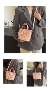 Detail of pink and beige bucket bag with butterfly print and cute puppy pendant