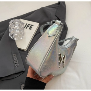 Dettaglio della borsa a spalla olografica argento con ciondolo a farfalla in metallo