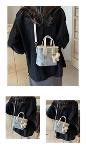 Close-up of blue butterfly print crossbody bag with cute dog charm and logo detail