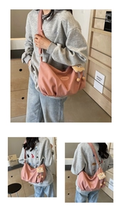 Detailed view of pink pleated tote bag featuring iFashion label and plush monster charm