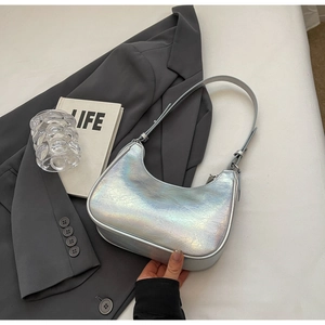 Dettaglio della borsa a mezzaluna argento laser con texture increspata su grigio