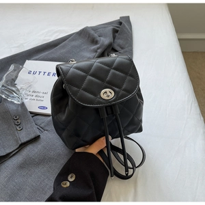 Détail du mini sac à dos noir matelassé avec fermoir rotatif argenté et cordon de serrage