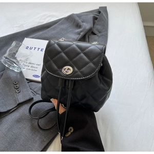 Gros plan du petit sac à dos matelassé noir avec fermoir métallique argenté et cordon
