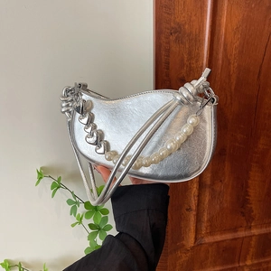 Silver crescent underarm bag with pearl chain and heart pendant in a chic handheld view