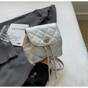 Détails d'un sac à dos argenté matelassé avec finition métallisée et chaîne