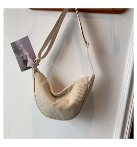 Detailed texture of beige corduroy half-moon bag with adjustable golden buckle strap