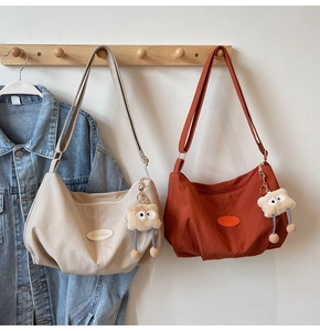 Detail view of large capacity tote bags with pleated nylon fabric and plush charms