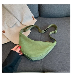 Detail of green corduroy dumpling bag with textured stripes and adjustable strap