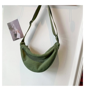Detail of green corduroy crescent bag showing soft textured fabric and shoulder strap
