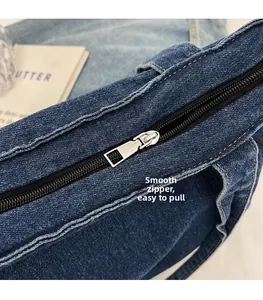 Detailansicht des glatten silbernen Reißverschlusses einer dunkelblauen Denim-Tasche