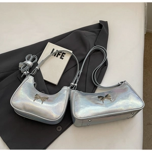 Dettaglio di borse a tracolla argento iridescente con fibbia a fiocco metallico su un blazer