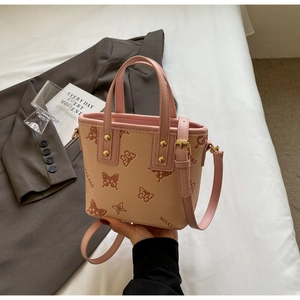 Close-up of pink and beige bucket bag with butterfly print and adjustable strap