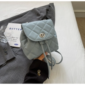Détail d'un sac à dos en cuir matelassé bleu clair avec fermoir rotatif et cordon de serrage