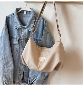 Detail of apricot large capacity hobo bag with iFashion logo and pleated fabric texture