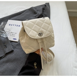 Détail du mini sac à dos matelassé crème avec fermoir rotatif en métal et cordon chaîne