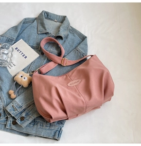 Detail view of pink pleated tote bag with adjustable strap and cute bear charm