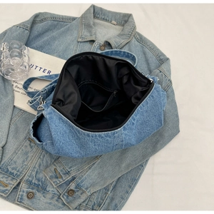 Détail intérieur du sac bandoulière en denim bleu avec grand espace et poche zippée