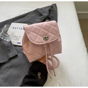Vue détaillée du mini sac à dos rose matelassé avec chaîne en argent et fermoir rotatif