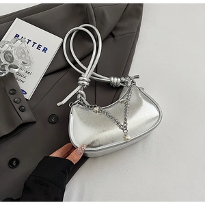 Detail of silver metallic dumpling bag with pleated texture and pearl chain charms