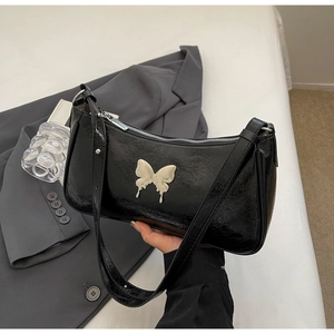 Dettaglio della borsa a spalla in pelle nera a pieghe con grande fibbia a farfalla in argento